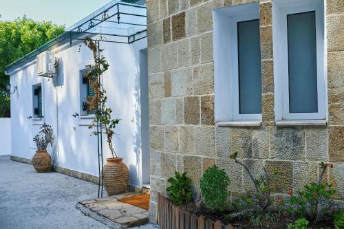 a facade of a house with white walls and windows at Villa Boukari in Chlomós