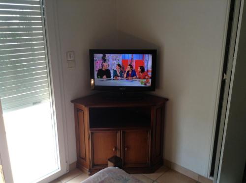 a television sitting on top of a wooden stand at Villa L'Adret et sa piscine in Juan-les-Pins
