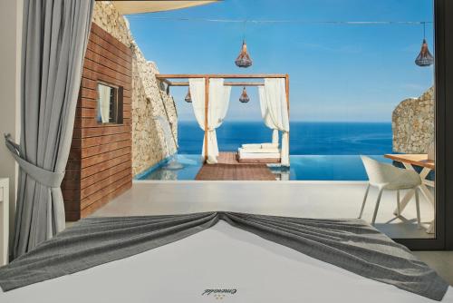 a bedroom with a bed with a view of the ocean at Emerald Villas & Suites - The Finest Hotels Of The World in Agios Nikolaos