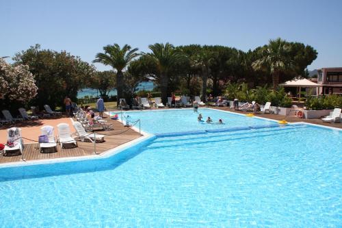 - une grande piscine avec des personnes séjournant dans un complexe dans l'établissement TH Costa Rei - Free Beach Resort, à Monte Nai