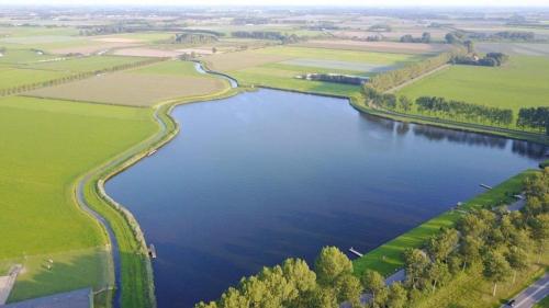 an aerial view of a river with green fields at Bij het meertje! in Dirkshorn