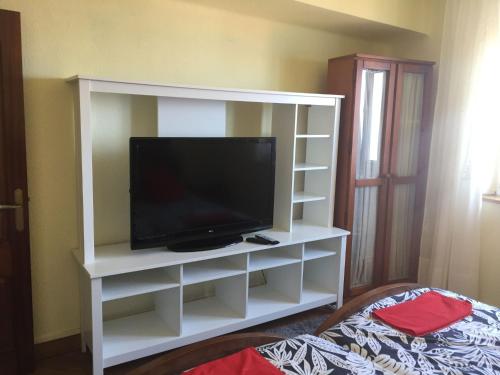 a white entertainment center with a flat screen tv at La casina del Reloj con vistas al mar in Lastres