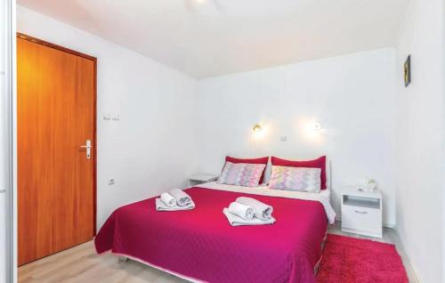 een slaapkamer met een rood bed en 2 handdoeken erop bij Apartment Mia in Krasica