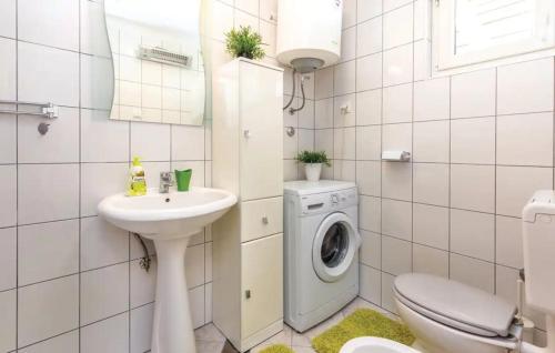 La salle de bains est pourvue d'un lave-linge et d'un lavabo. dans l'établissement Apartment Mia, à Krasica
