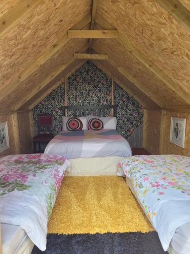 a bedroom with two beds in a attic at Shannon Estuary Glamping in Effernan