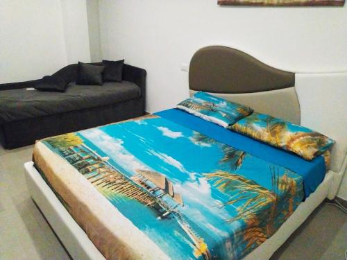 a bedroom with a bed with a painting of a beach at casa Marinello in Oliveri