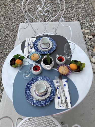 a table with plates and utensils on a table at Combo Rooms in Garna dʼAlpago