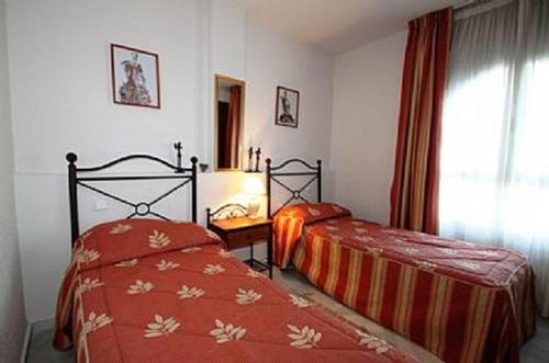 sypialnia z dwoma łóżkami i oknem w obiekcie Balcones del Chaparral, Mijas Costa w mieście Mijas Costa