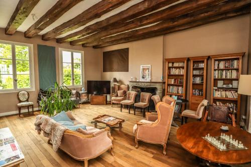 a living room filled with furniture and a table at Le Grand Presbytère de Beaulieu in Beaulieu-lès-Loches