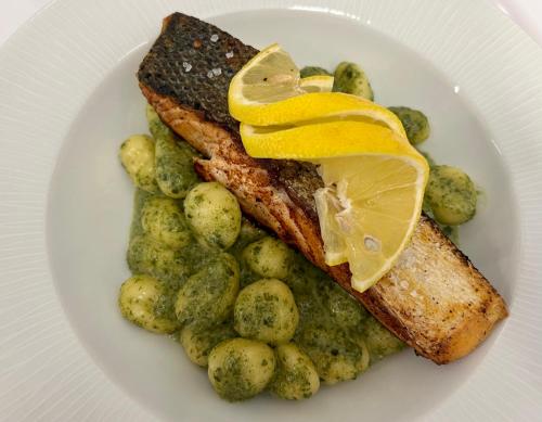 a plate of food with fish and potatoes with lemon slices at Holiday Resorts in Balatonszárszó