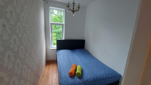 a room with a bed with two carrots on it at Jungas nams in Liepāja