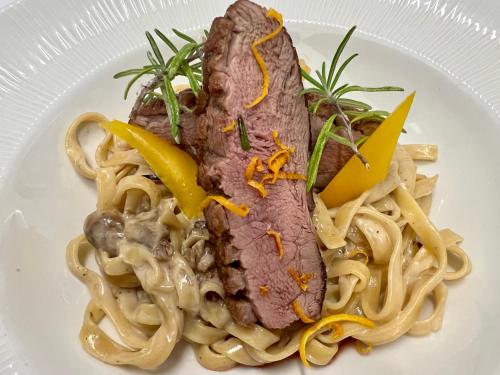 a plate of food with noodles and meat on it at Holiday Resorts in Balatonszárszó
