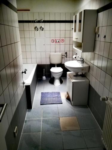 a bathroom with a sink and a toilet and a tub at Ferienwohnung Axel - nahe Chemnitz in Limbach - Oberfrohna