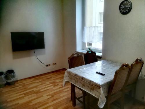 a dining room with a table and a television on a wall at Ferienwohnung Axel - nahe Chemnitz in Limbach - Oberfrohna