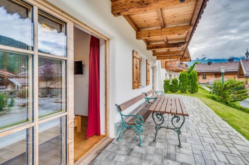 a patio with a wooden bench and a table at Chaletdorf am Sonnenhang in Neukirchen am Großvenediger