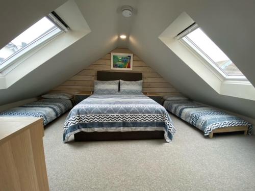 een slaapkamer op zolder met 4 bedden en dakramen bij The Studio in Worthing