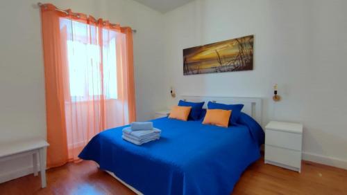 Un dormitorio con una cama azul y una ventana en Apartamento do Marquês, en Santa Cruz das Flores
