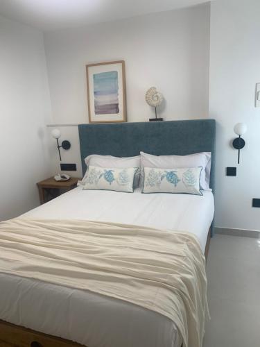 a bedroom with a large bed with a blue headboard at Mar De Muros in Muros