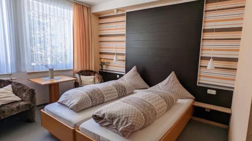 Un dormitorio con una cama con almohadas. en Hotel Heilbrunnen en Jöhstadt
