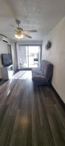 a living room with a couch and a ceiling fan at Nouveau bien lumineux tout confort en centre ville in Sète