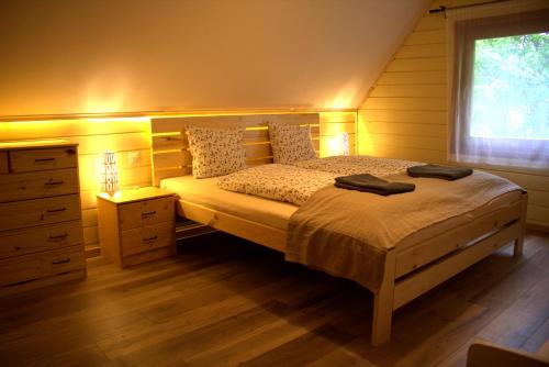 1 dormitorio con 1 cama con tocador y ventana en Lili's Lovely Log Home in the Forest, en Bükkszentkereszt