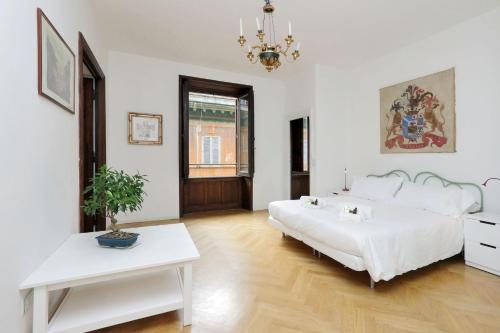 a white bedroom with a bed and a table at Condotti Charme - My Extra Home in Rome