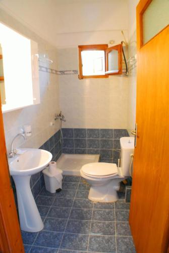 a bathroom with a toilet and a sink at Studios Efi in Kala Nera