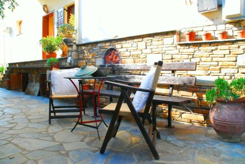 a table and chairs sitting next to a stone wall at Studios Efi in Kala Nera