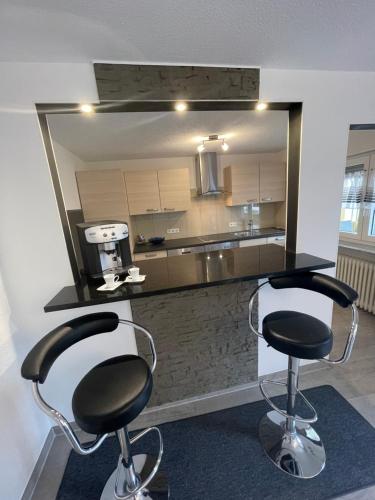 a kitchen with two bar stools in front of a counter at Haus Annabell Diese Unterkunft steht Baufirmen nicht zur Verfügung in Bad Krozingen
