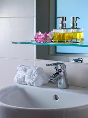 a white bathroom sink with a towel on it at Mistral Bay Hotel in Agios Nikolaos