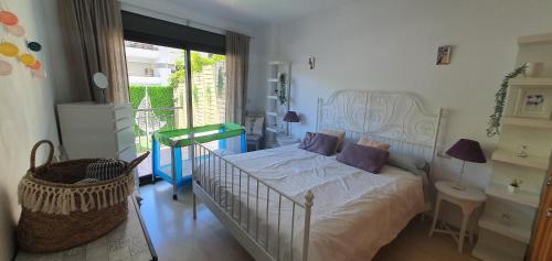 um quarto com uma cama branca e almofadas roxas em Apartamento con jardín y piscina em Marbella