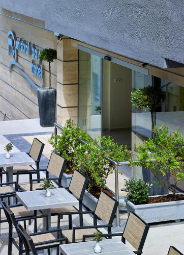 a group of tables and chairs in front of a building at Mistral Bay Hotel in Agios Nikolaos