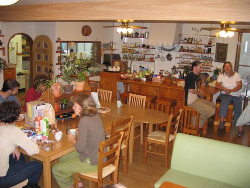 a group of people sitting at tables in a restaurant at Backpackers Hostel Ino's Place in Sapporo