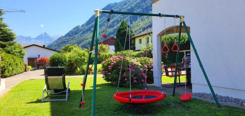 a swing set in a yard with a house at 2 rooms Appartment "Home, Swiss Home" in Bilten