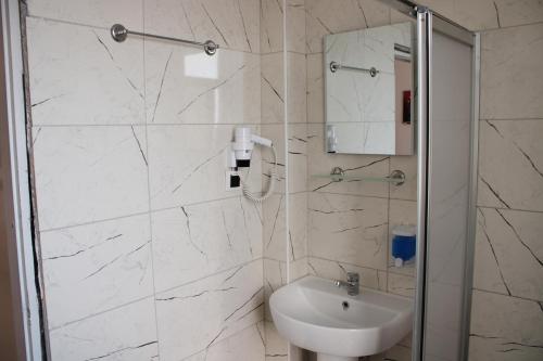a white bathroom with a sink and a shower at BIN BILLA HOTEL in Alanya