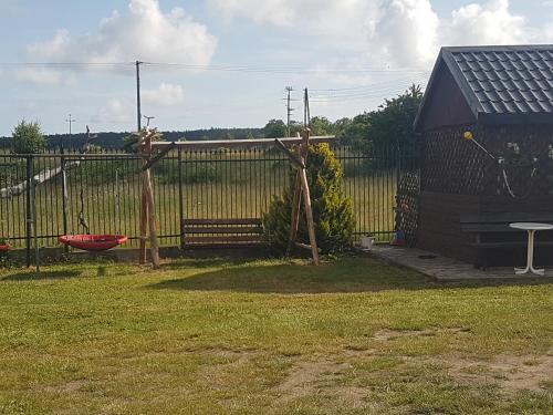 a fence in a yard with a swing at Pokoj agroturystyczny in Mieroszyno