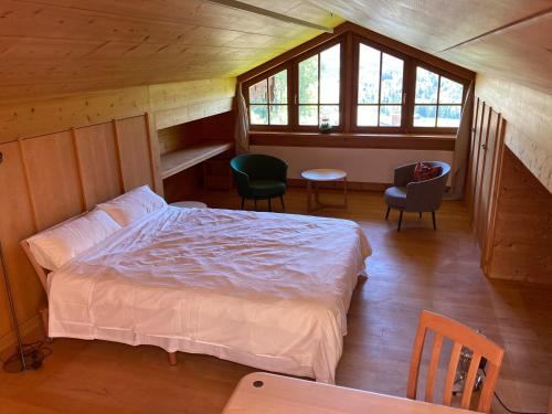 a bedroom with a bed and chairs in a cabin at Watzmann in Bischofswiesen