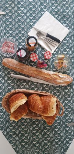 - une table avec un plateau de pain et des croissants dans l'établissement Chambre Le mans avec salle de bain privée, au Mans