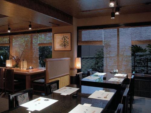 a restaurant with a dining room with tables and a counter at Hotel Edoya in Tokyo