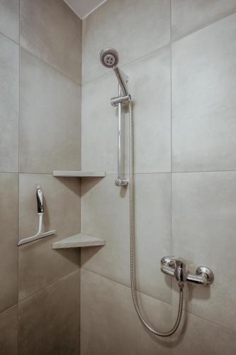 a shower with a shower head in a bathroom at B&B Sobe Lušina in Sečovlje