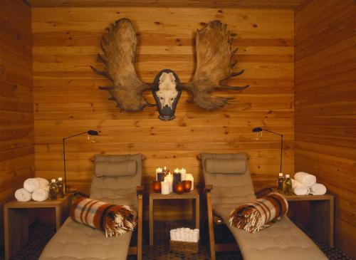 a room with two chairs and a wall with antlers at Kristiania Lech in Lech am Arlberg