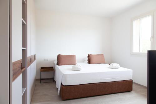 a white bedroom with a bed and a window at Villa Umberto in San Giovanni in Marignano