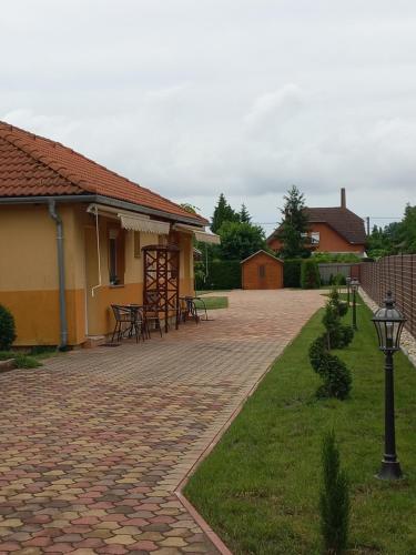 a brick patio with tables and chairs next to a building at Mediterrán Vendégház in Nagyatád