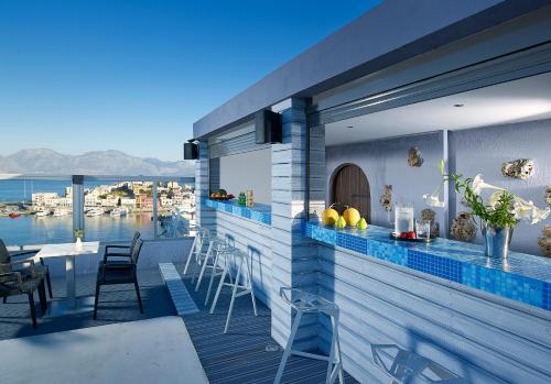 a balcony with a bar with a view of the water at Mistral Bay Hotel in Agios Nikolaos