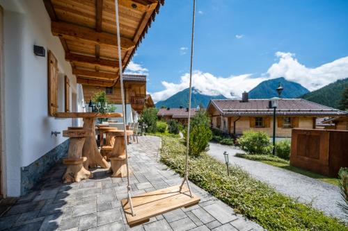 a porch of a house with a swing at Chaletdorf am Sonnenhang in Neukirchen am Großvenediger