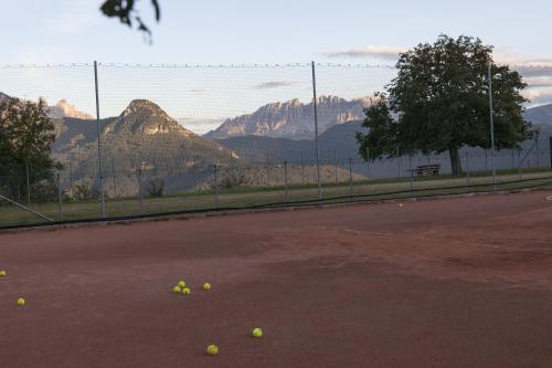 a tennis court with tennis balls on the ground at Hotel Bemelmans-Post in Collalbo