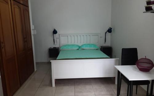 Un dormitorio con una cama blanca con almohadas azules. en Villa colonial suite n 4 basic interior, en Río San Juan