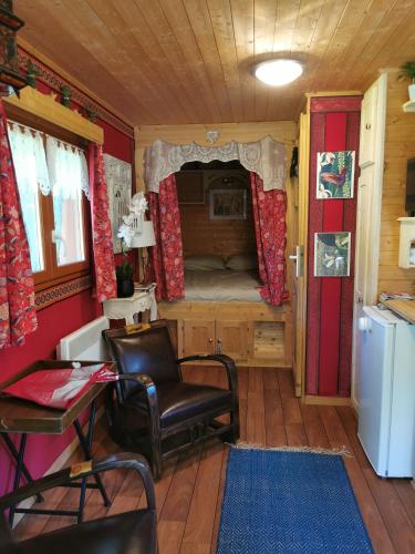 une petite pièce avec un lit, une table et des chaises dans l'établissement Roulotte HOPE-Le jardin de Mia, à Paradou