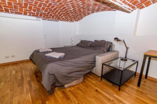 - une chambre avec un lit et un mur en briques dans l'établissement Industrial Loft [center of Turin], à Turin