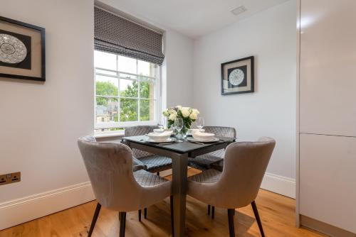 a dining room with a black table and chairs at Bath Circle in Bath